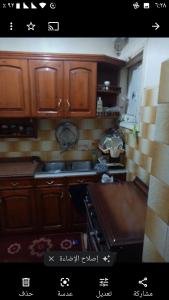a kitchen with wooden cabinets and a stove top oven at Gibran residence in Kafr al Ishārah