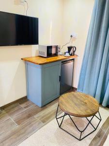 a table with a microwave and a chair in a room at Seqonoka Villa Accommodation & Events Park in Berea Hills