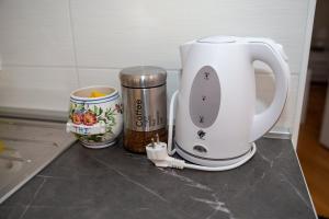 a white coffee maker and a cup on a counter at Alma apartments in Mostar