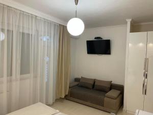 salon z kanapą i telewizorem na ścianie w obiekcie Adam Apartman w Hajduszoboszlo