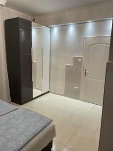 um quarto com uma cabina de duche ao nível do chão ao lado de uma cama em Adam Apartman em Hajdúszoboszló