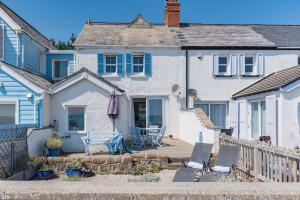 Casa blanca con patio, mesa y sillas en Wave Cottage by Bloom Stays en Sandgate