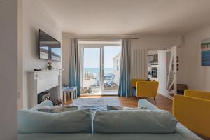 a living room with a couch and a view of the ocean at Wave Cottage by Bloom Stays in Sandgate