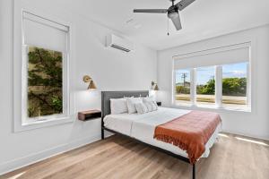 1 dormitorio blanco con 1 cama y 2 ventanas en 10 Ocean A Powered By Atkinson Realty, en Virginia Beach