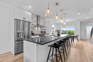 a kitchen with a large island with black counter stools at 10 Ocean A Powered By Atkinson Realty in Virginia Beach