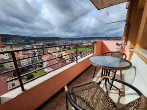 a balcony with a table and chairs and a view at Cuña Buenavista in Ourense
