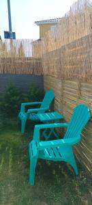 2 chaises de jardin bleues assises dans la cour dans l'établissement Maison avec piscine privée aux portes des Cévennes, à Saint-Christol-lès-Alès