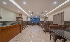 a restaurant with tables and chairs in a room at Treebo Aaravi Residency, 800 Mtrs From Promenade Beach in Puducherry