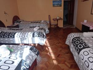 Pokój z 4 łóżkami z szarą i białą pościelą w obiekcie HOSTAL MAYA INN w mieście La Paz