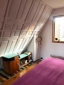 a bedroom with a pink bed and a window at Czekoladowy Domek in Nadkole