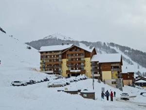 a group of people standing in the snow in front of a building at Appartement 1 chambre, calme, vue dégagée, La Foux in La Foux