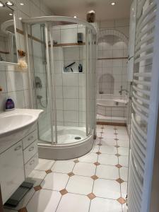 een badkamer met een douche, een wastafel en een bad bij Luxury Apartment near City Media Harbour in Düsseldorf