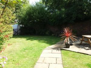 a garden with a table and a potted plant at Sunnyside Cottage in Filey +4 photos