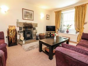 a living room with a table and a fireplace at Tennant Cottage in Malham