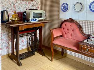 a room with a red chair and a table with a microwave at Camera Romantica con Giardino in Dimora Storica - B&B Palazzo Robicci in Castiglion Fiorentino