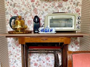 a microwave and a toaster oven on top of a table at Camera Romantica con Giardino in Dimora Storica - B&B Palazzo Robicci in Castiglion Fiorentino +30 photos