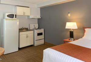 um quarto de hotel com uma cama e uma cozinha em Coast Hinton Hotel em Hinton