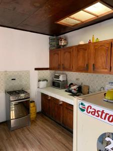 a kitchen with wooden cabinets and a stove top oven at Hostal Natural in Santa Ana