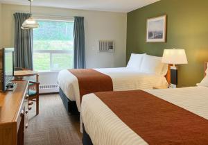 um quarto de hotel com duas camas e uma janela em Coast Hinton Hotel em Hinton