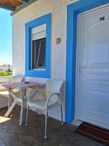 a room with a table and chairs and a door at Βig Βlue Apartments in Makry Gialos