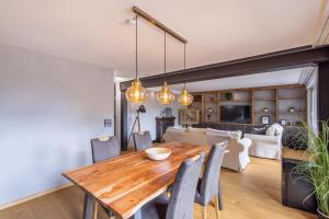 a dining room and living room with a wooden table and chairs at Lucky Fox in Leukerbad