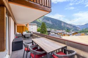 a balcony with a wooden table and chairs at Lucky Fox in Leukerbad