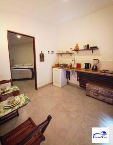 a room with a kitchen and a room with a bed at Casa Tua Pipa in Pipa