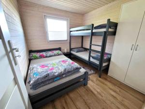 ウストロニエ・モルスキエにあるFajne domkiの二段ベッド2台、窓が備わる小さな客室です。
