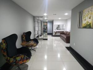 sala de estar con 2 sillas y sofá en Excelente Apartamento Edf Bellagio - Praia do Morro, en Guarapari