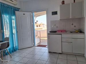 a kitchen with a door open to a balcony at Βig Βlue Apartments in Makry Gialos