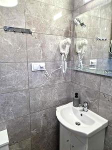 uma casa de banho com um lavatório branco e um espelho. em Fajne domki em Ustronie Morskie