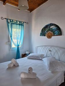 a bedroom with a white bed with towels on it at Βig Βlue Apartments in Makry Gialos