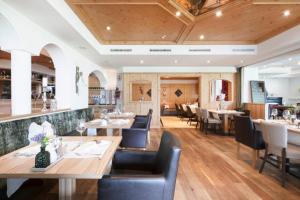 restauracja z drewnianymi sufitami, stołami i krzesłami w obiekcie LifestylePanoramaHotel Erika Superior w Neustift im Stubaital
