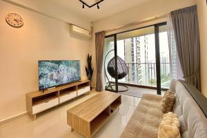 a living room with a flat screen tv and a couch at Cozy Beach Escape: 2BR Muji Gem in Johor Bahru