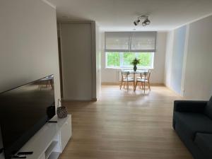 a living room with a couch and a table with chairs at Roja Lux Apartment in Roja