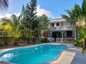 a swimming pool in front of a house at Blue Paradise in Blue Bay