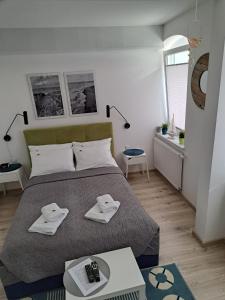 ein Schlafzimmer mit einem Bett mit zwei Handtüchern darauf in der Unterkunft Apartamenty Via Mare in Ustka