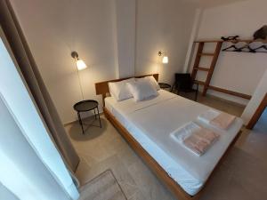 Un dormitorio con una cama con sábanas blancas y una escalera en Seastone, en Ierissos