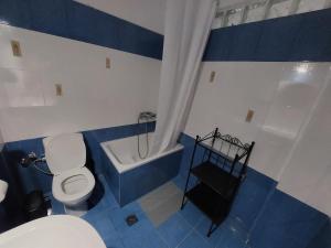 Seastone في إيريسوس: حمام من اللون الأزرق والأبيض مع مرحاض وحوض استحمام