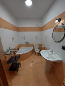 a bathroom with a tub and a toilet and a sink at Seastone in Ierissos
