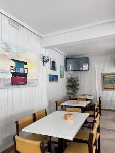 擻莫的住宿－Hostería Somo，一间带桌椅和电视的用餐室