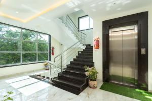 a staircase in a house with a glass door and a window at Blugent Residency in Boisar