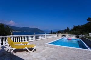a yellow chair sitting next to a swimming pool at Mountain Bay View Apartments in Njivice