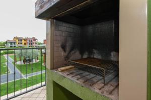 een persoon staat over een grill op een balkon bij Apartment baglio degli ulivi in Sirmione