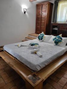 duże drewniane łóżko z niebieskimi poduszkami w sypialni w obiekcie Locanda delle sorelle w mieście Campagnano di Roma