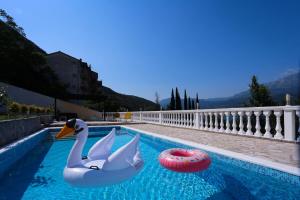 two swans in a swimming pool with a ball at Mountain Bay View Apartments in Njivice