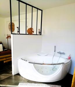 a white bath tub sitting in a room at Aux Couleurs d'Alsace in Ostwald