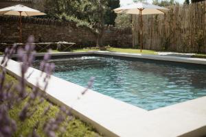 a swimming pool with two umbrellas in a yard at Maison B in Bouchet