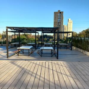 a pavilion with tables and benches on a wooden deck at Torres Brickell Departamento -MALVAN- 1A in Tigre