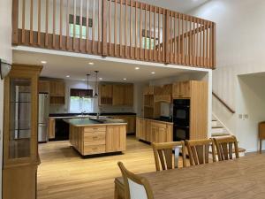 una grande cucina con armadi in legno e un tavolo in legno di Beautiful Spacious Home w/ Game Room. a Gilford